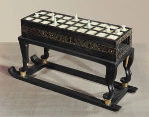 One of four senet game boards found in the tomb. Legs and connecting base are made of blackwood and box is veneered with blackwood and inlaid with ivory.