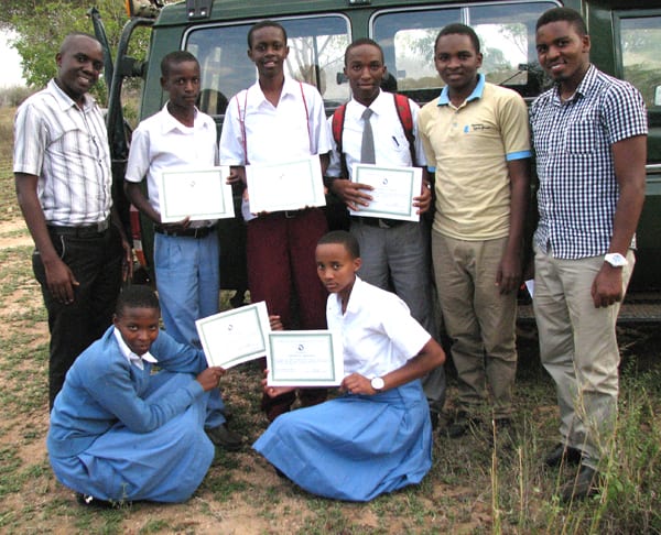 Cyril and Michael (rt) supplied tree seedlings from the ABCP nursery for a Roots and Shoots graduation ceremony. Successful students display their diploma certificates.